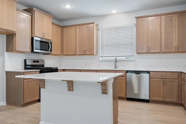 a kitchen with stainless steel appliances granite countertop a sink and a microwave