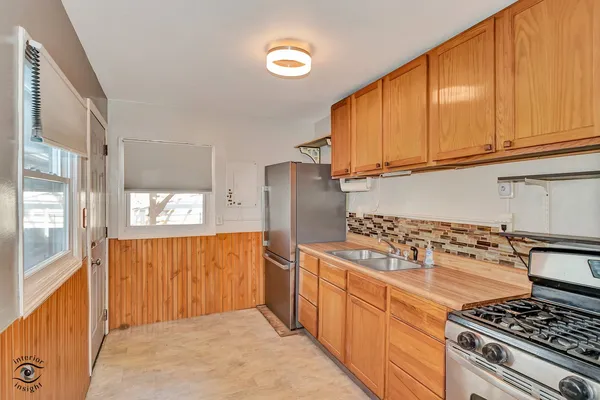 a kitchen with stainless steel appliances granite countertop a stove a refrigerator and wooden cabinets