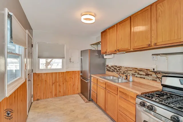 a kitchen with stainless steel appliances granite countertop a stove a refrigerator and wooden cabinets