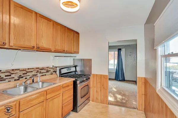 a kitchen with stainless steel appliances granite countertop a sink a stove cabinets and wooden floor