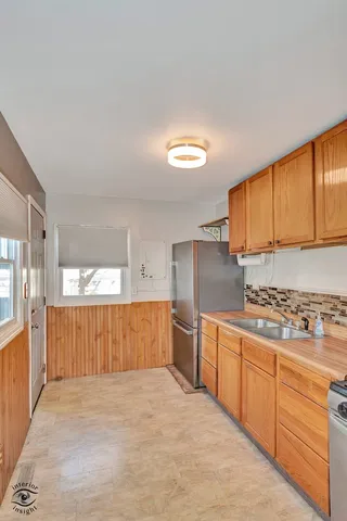 a large kitchen with stainless steel appliances granite countertop a stove a sink and a refrigerator