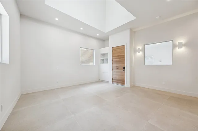 an empty room with a bathroom and windows