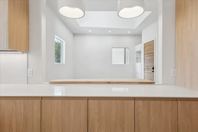 a kitchen with white cabinets and a window