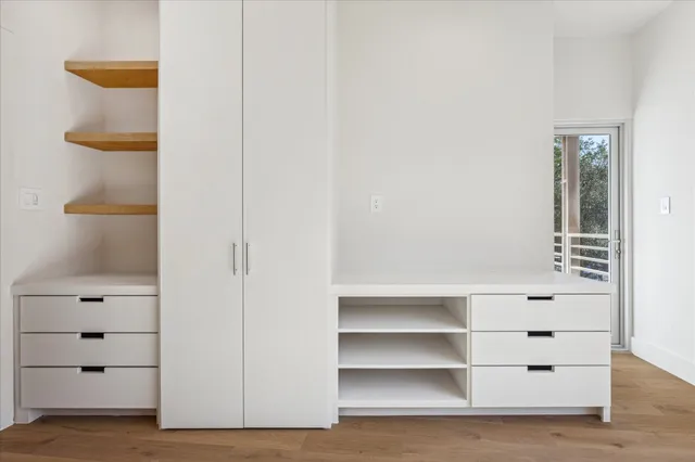 an empty room with cabinet and mirrors