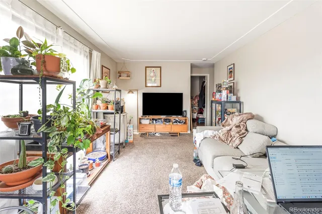 a living room with furniture a flat screen tv and a floor to ceiling window