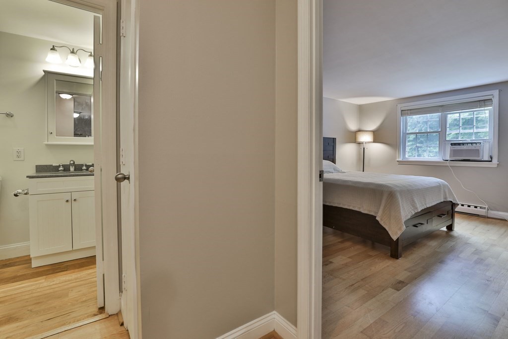 56 Leonard Road, Unit 56 Boxborough, MA 01719 - Photo 15 of 26 a bedroom with a bed and wooden floor