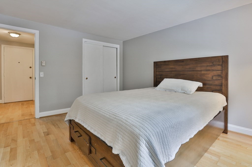 56 Leonard Road, Unit 56 Boxborough, MA 01719 - Photo 18 of 26 a bedroom with a bed and wooden floor