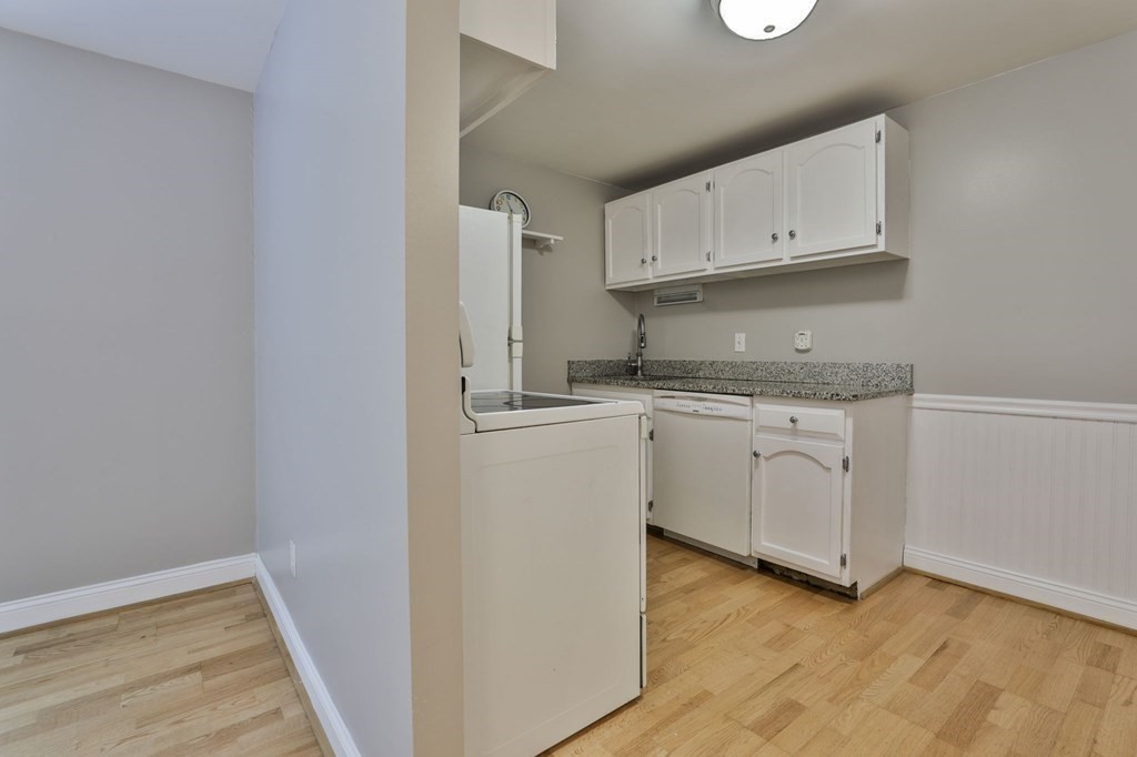 56 Leonard Road, Unit 56 Boxborough, MA 01719 - Photo 7 of 26 a kitchen with granite countertop white cabinets and white appliances
