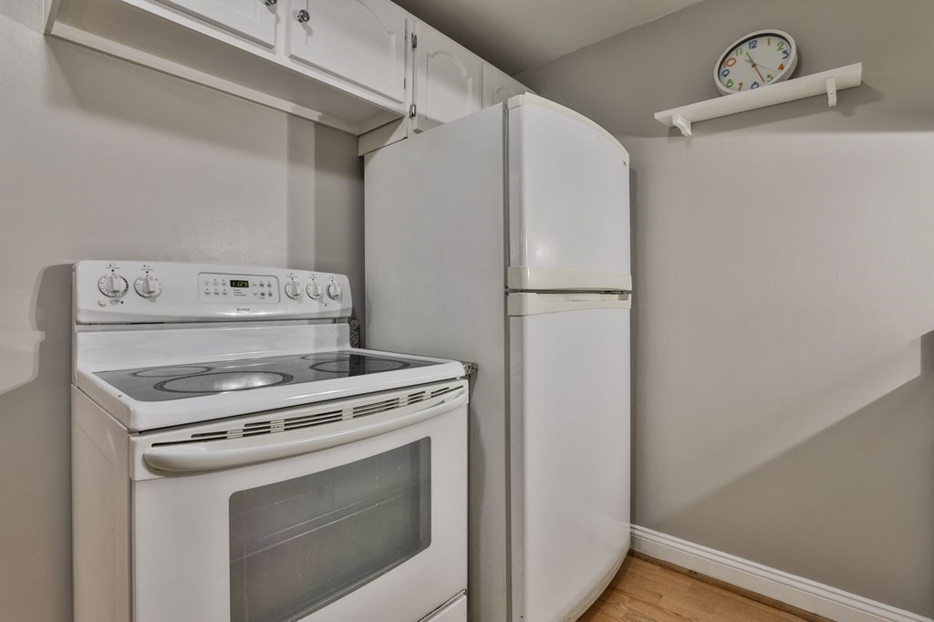 56 Leonard Road, Unit 56 Boxborough, MA 01719 - Photo 8 of 26 a kitchen with a stove and a refrigerator