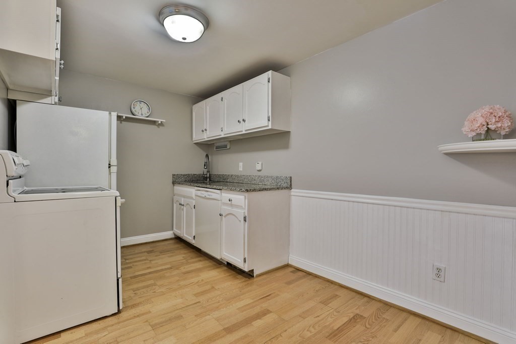 56 Leonard Road, Unit 56 Boxborough, MA 01719 - Photo 9 of 26 a kitchen with sink cabinets and wooden floor