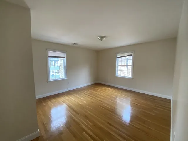 a view of empty room with wooden floor and fireplace