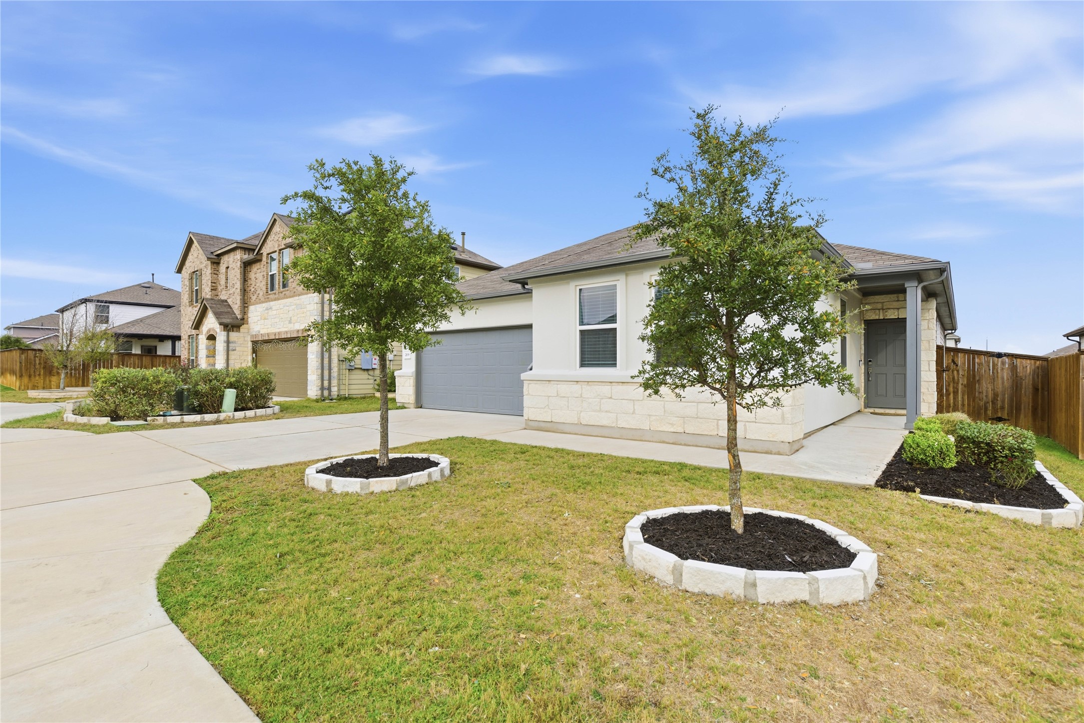 Obstructed view of property featuring concrete driveway, a garage, and stucco siding