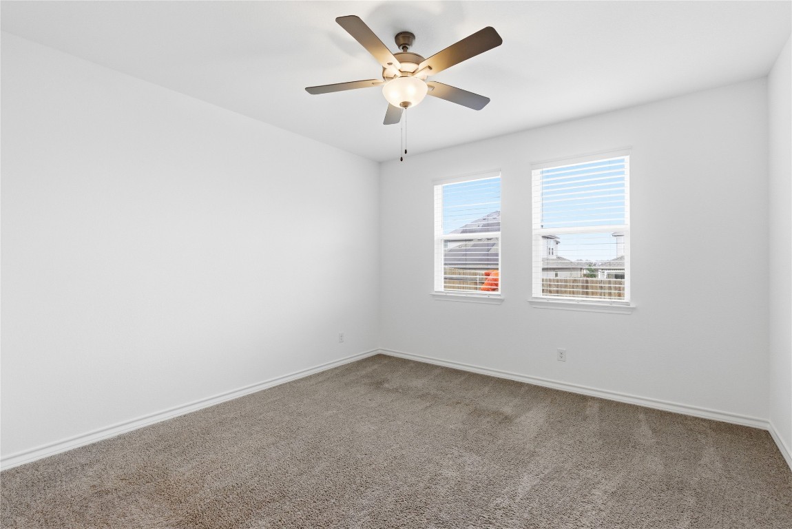 209 Thurman Holt Road Hutto, TX 78634 - Photo 18 of 32 an empty room with a window and a ceiling fan