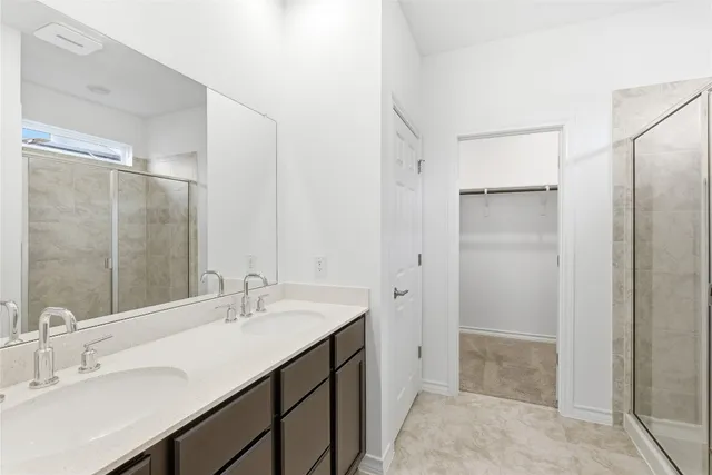 a bathroom with a double vanity sink mirror and shower