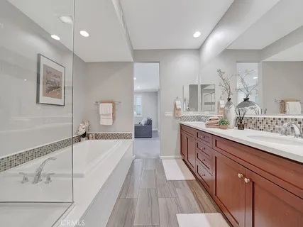 a spacious bathroom with a granite countertop sink mirror and bathtub