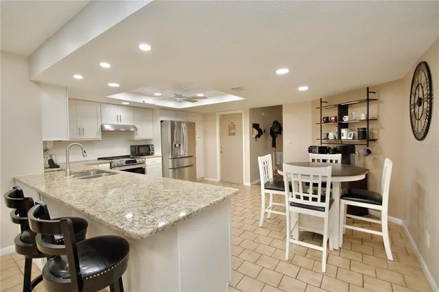 a kitchen with a dining table chairs and refrigerator