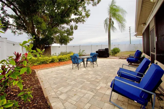 a view of a patio with table and chairs under an umbrella
