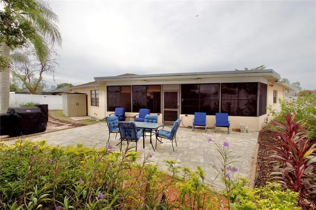 a view of a patio with table and chairs potted plants and a large tree