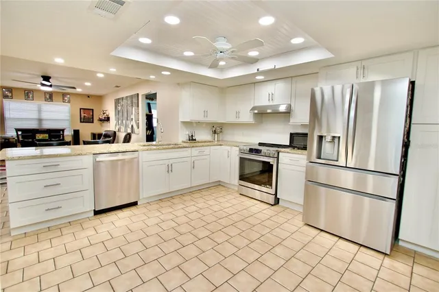 a kitchen with white cabinets and stainless steel appliances