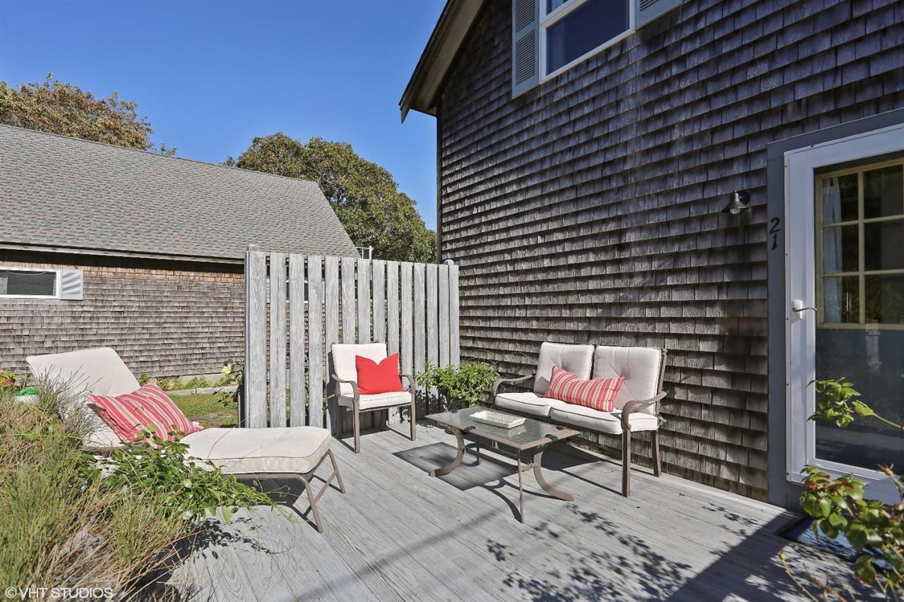 21 Riverside Road Mashpee, MA 02649 - Photo 4 of 14 a patio with table and chairs and potted plants
