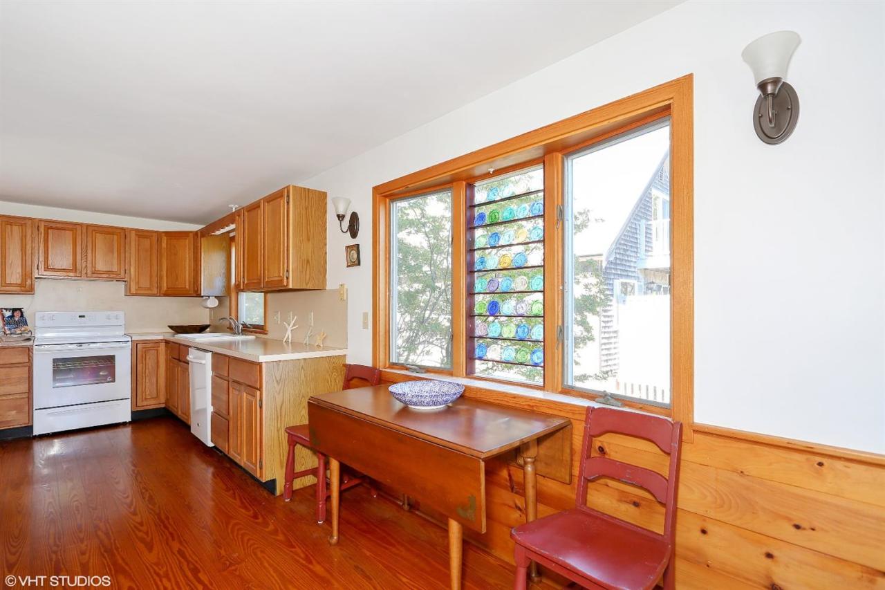 21 Riverside Road Mashpee, MA 02649 - Photo 8 of 14 a open kitchen with stainless steel appliances granite countertop a stove a sink dishwasher and a microwave with wooden floor