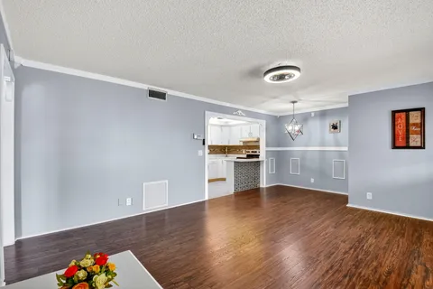 a view of a kitchen with wooden floor and electronic appliances