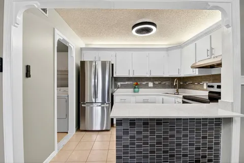 a kitchen with stainless steel appliances granite countertop a refrigerator and a stove