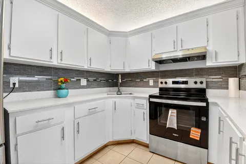 a kitchen with stainless steel appliances granite countertop a sink a stove and cabinets