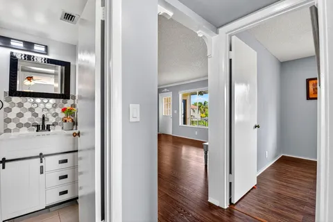 a view of a hallway with wooden floor and closet