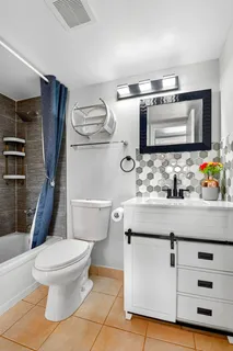 a bathroom with a sink a toilet a mirror and shower