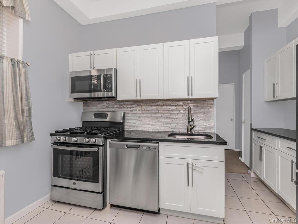 245 Rumsey Road, Unit 20 Yonkers, NY 10701 - Photo 7 of 14 a kitchen with white cabinets and appliances