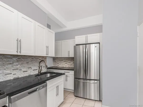 a kitchen with stainless steel appliances granite countertop a refrigerator sink and cabinets