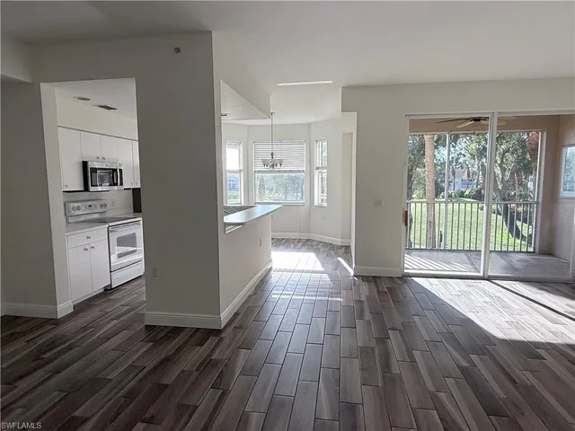 a view of a hardwood floor and windows in a room