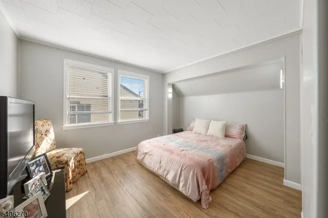 a bedroom with a bed television and a window