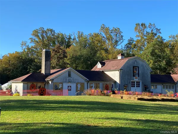 a front view of house with a garden and trees