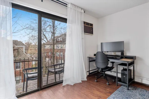 a view of a workspace with furniture and a window