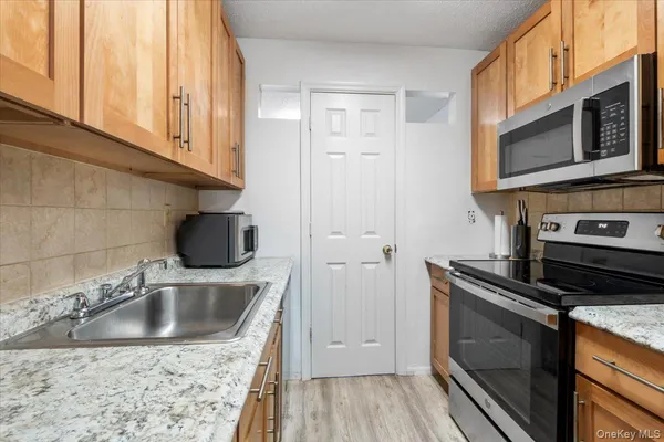 a kitchen with stainless steel appliances granite countertop a sink stove and microwave