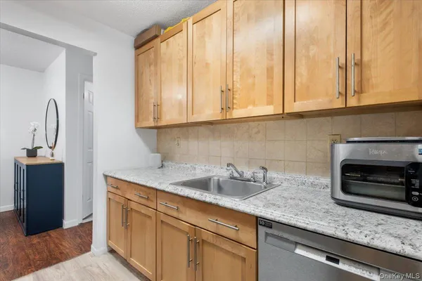 a kitchen with stainless steel appliances granite countertop a sink and a white cabinets