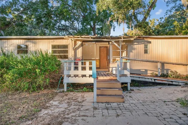 a view of house with a yard and sitting area