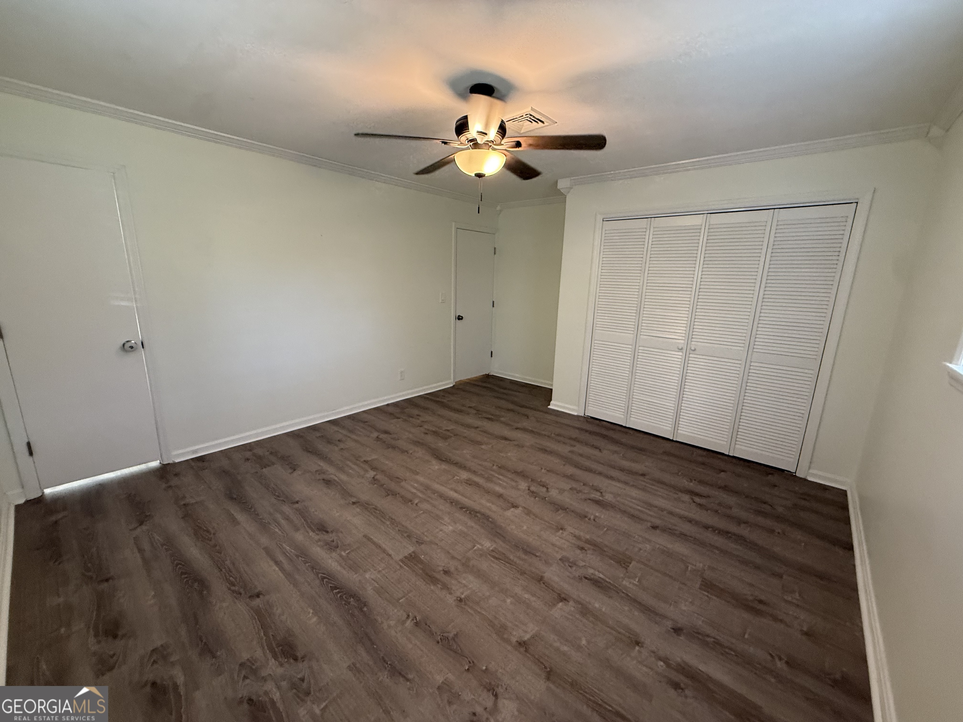 108 Plum Street Dublin, GA 31021 - Photo 18 of 33 a view of an empty room with wooden floor and a chandelier fan