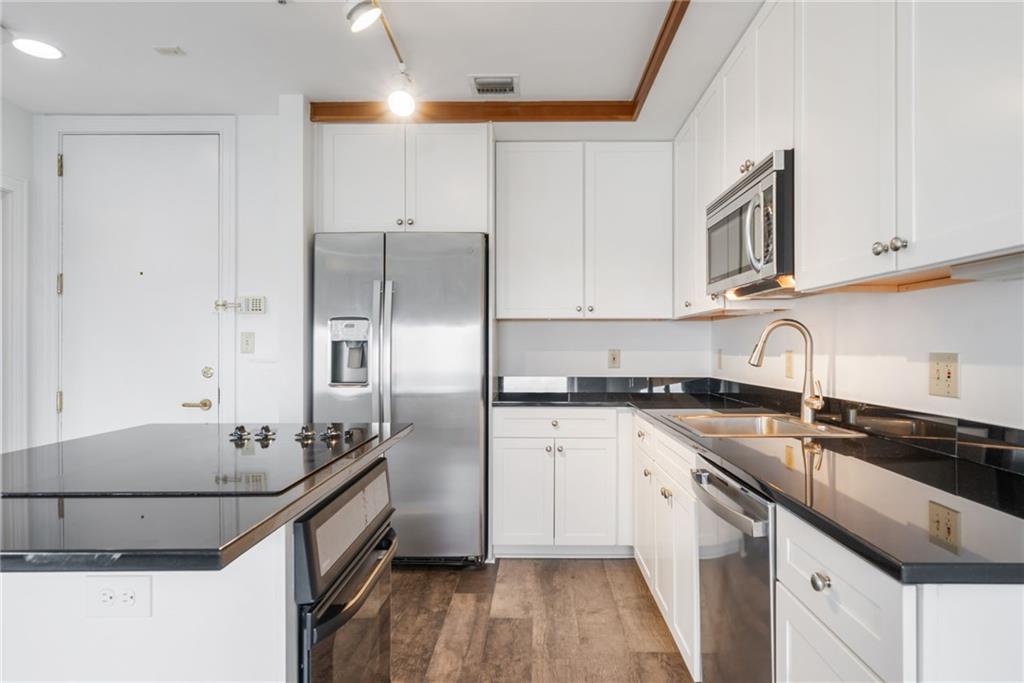 57 Forsyth Street Northwest, Unit 16G Atlanta, GA 30303 - Photo 13 of 27 a kitchen with stainless steel appliances granite countertop a sink stove and refrigerator