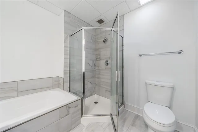 a bathroom with a tub sink shower and mirror