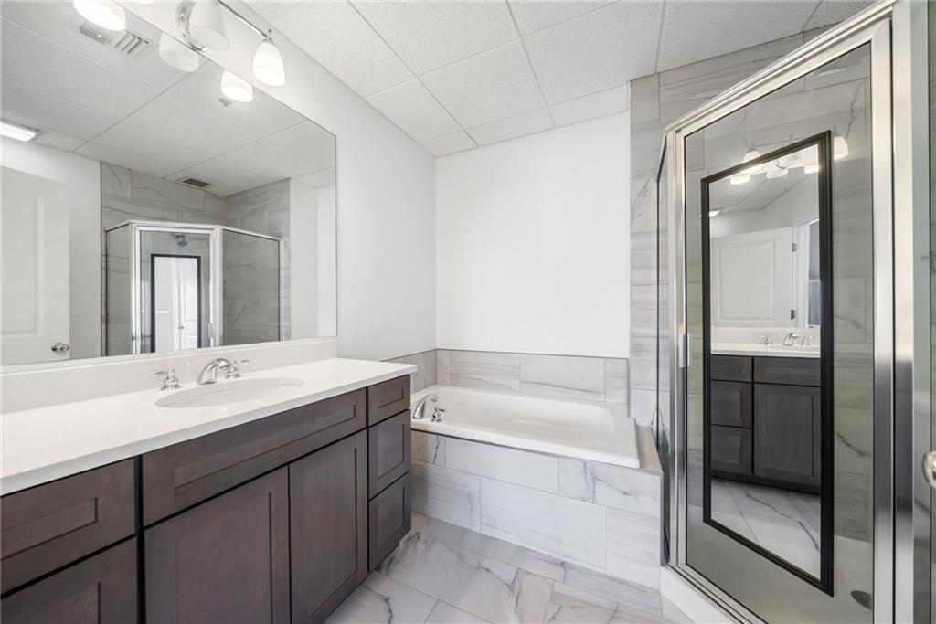 57 Forsyth Street Northwest, Unit 16G Atlanta, GA 30303 - Photo 15 of 32 a bathroom with a tub sink shower and mirror