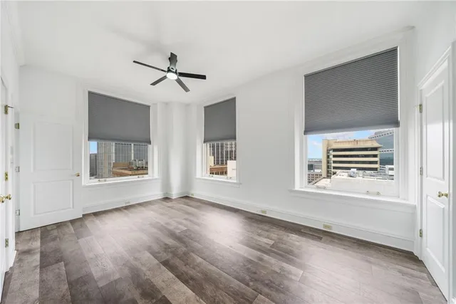 a view of an empty room with a window and wooden floor