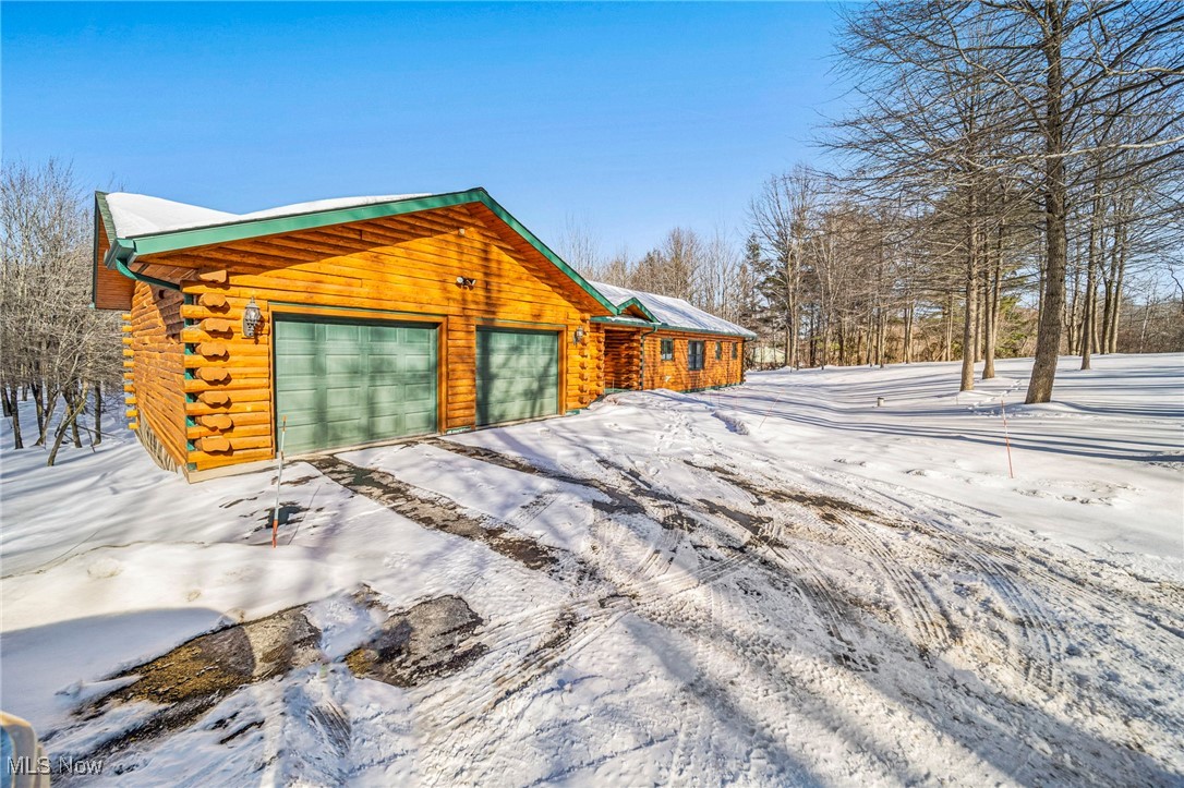 282 South Ridge Road West Conneaut, OH 44030 - Photo 2 of 49 View of snowy exterior featuring a garage and an outbuilding