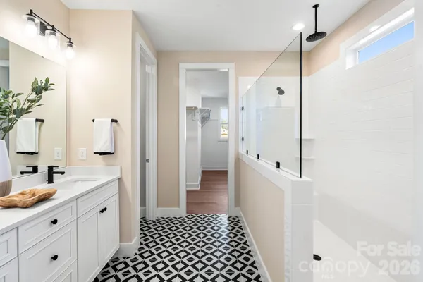 a spacious bathroom with a double vanity sink a mirror a shower and a bathtub