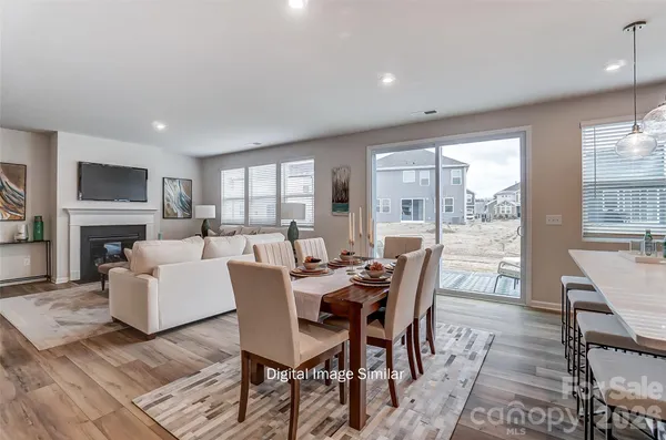 a dining room with furniture a fireplace and wooden floor