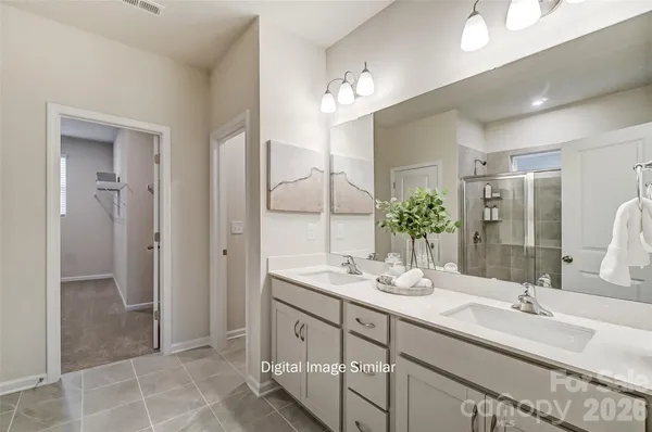 a bathroom with a double vanity sink mirror and shower