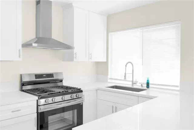 a kitchen with stainless steel appliances granite countertop a stove and a sink with white countertops
