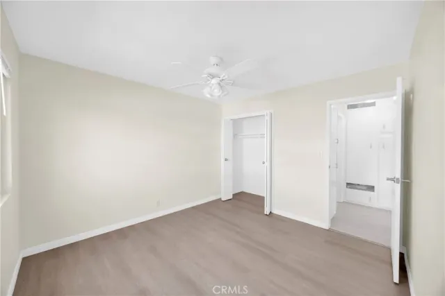 an empty room with a ceiling fan and a window